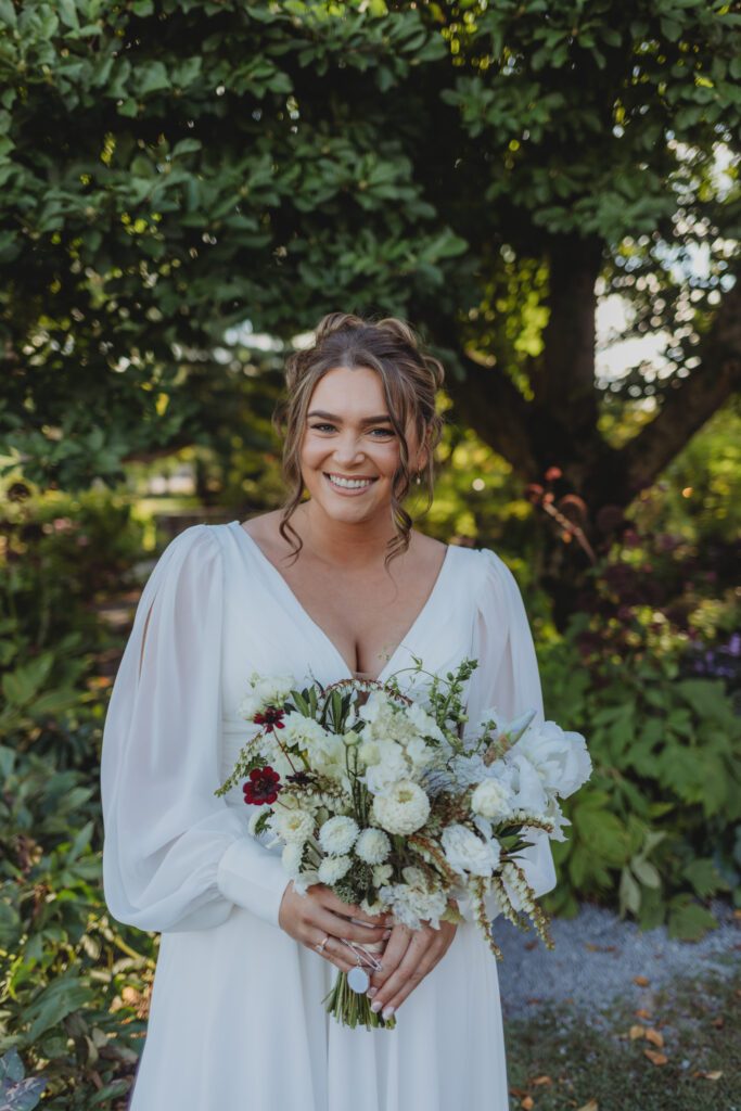 Bride smiling at whimsical outdoor wedding at New England Botanical Garden at Tower Hill in Boylston, Massachusetts.
