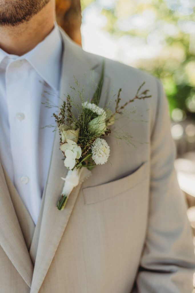 Close up of grooms boutonniere for romantic greenhouse wedding at Tower Hill in Boylston, Massachusetts.