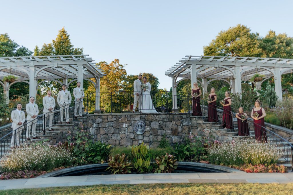 Bridal party standing on stone stairs in an editorial way New England Botanical Garden at Tower Hill in Boylston, Massachusetts