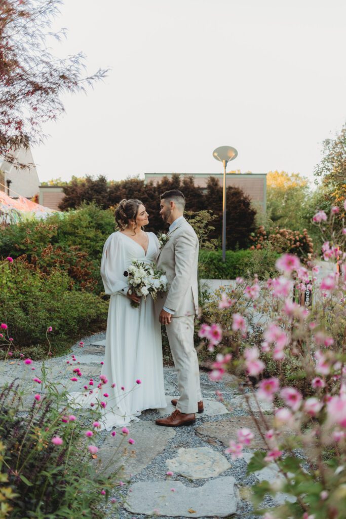 Bride and groom looking at each other as they stand in a garden at Tower Hill in Boylston, Massachusetts.