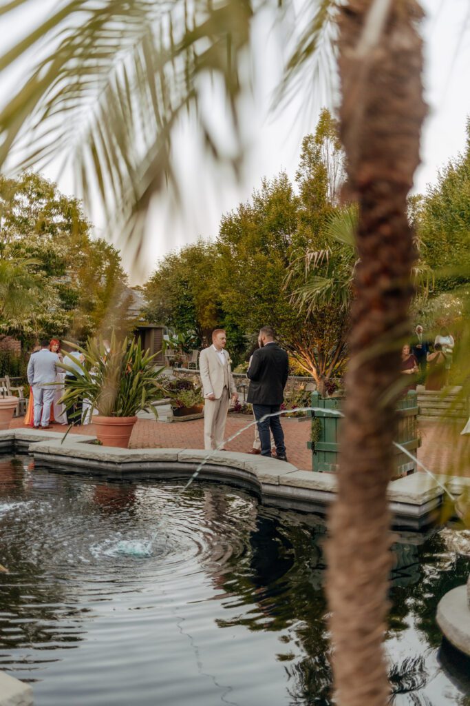 Guests talking during cocktail hour next to a water fixture at Tower Hill in Boylston, Massachusetts.