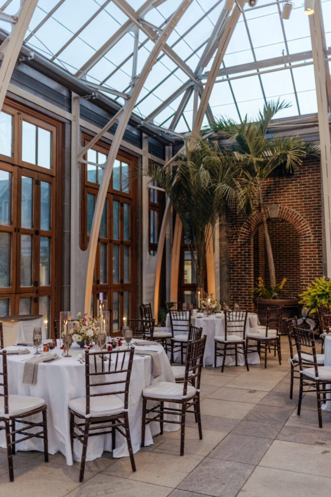 Wedding reception set up of tables, and chairs in a greenhouse at Tower Hill in Boylston, Massachusetts.