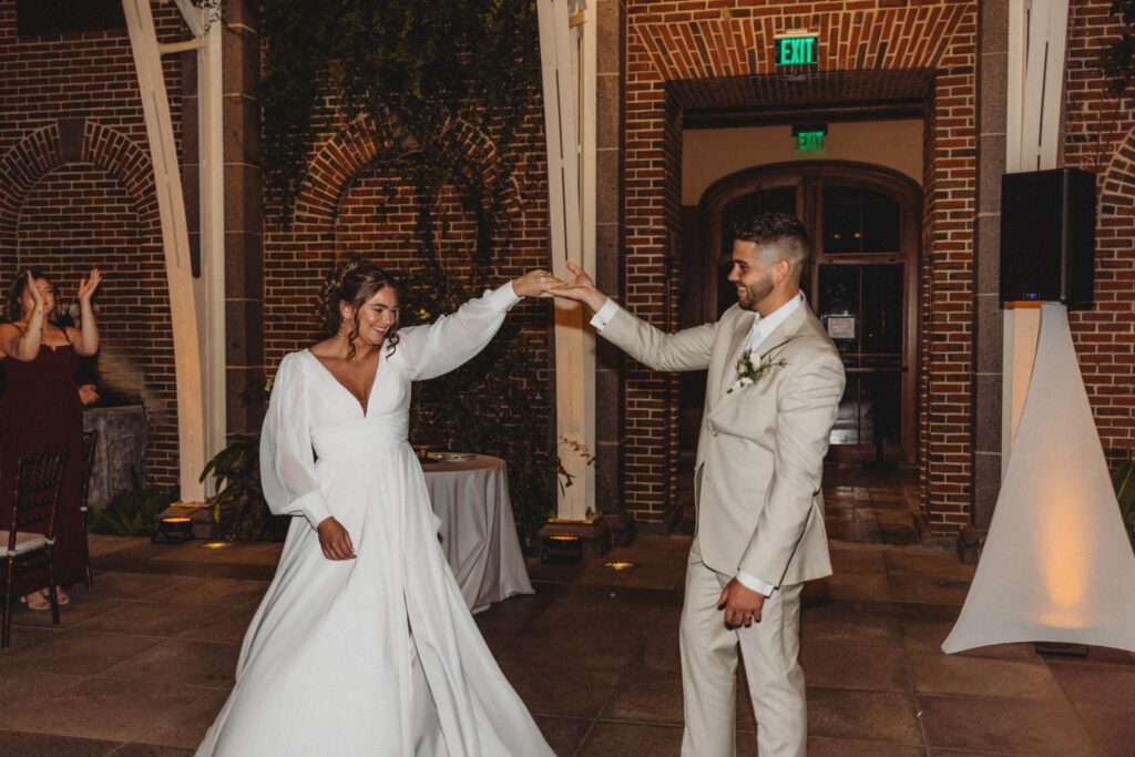 Bride and groom smiling and spinning during their first dance in a greenhouse at Tower Hill in Boylston, Massachusetts.