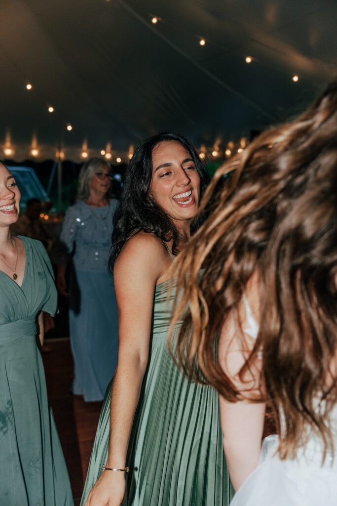 Guest smiling and dancing on dance floor during reception in Massachusetts.
