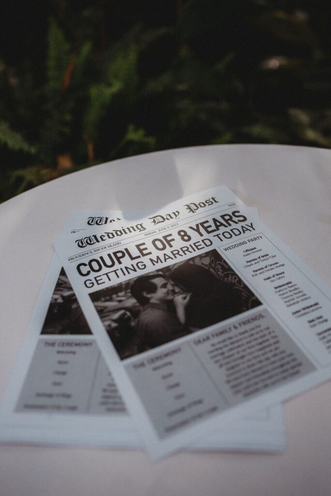 Wedding newspaper laying on table that says "Couple of 8 years getting married today" at Roger Williams Botanical Garden Park in Providence Rhode Island.