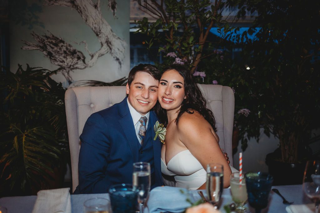 Bride and groom smiling during wedding reception in greenhouse at Roger Williams Botanical Garden Park in Providence, Rhode Island.