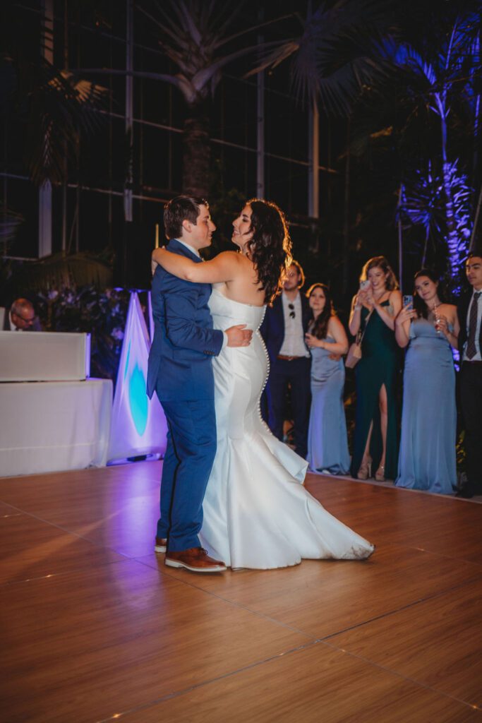 Bride and groom sharing romantic first dance in greenhouse at Roger Williams Botanical Garden Park in Providence, Rhode Island.
