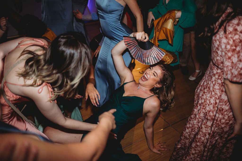 Guest dancing during wedding reception in greenhouse at Roger Williams Botanical Garden Park in Providence, Rhode Island.