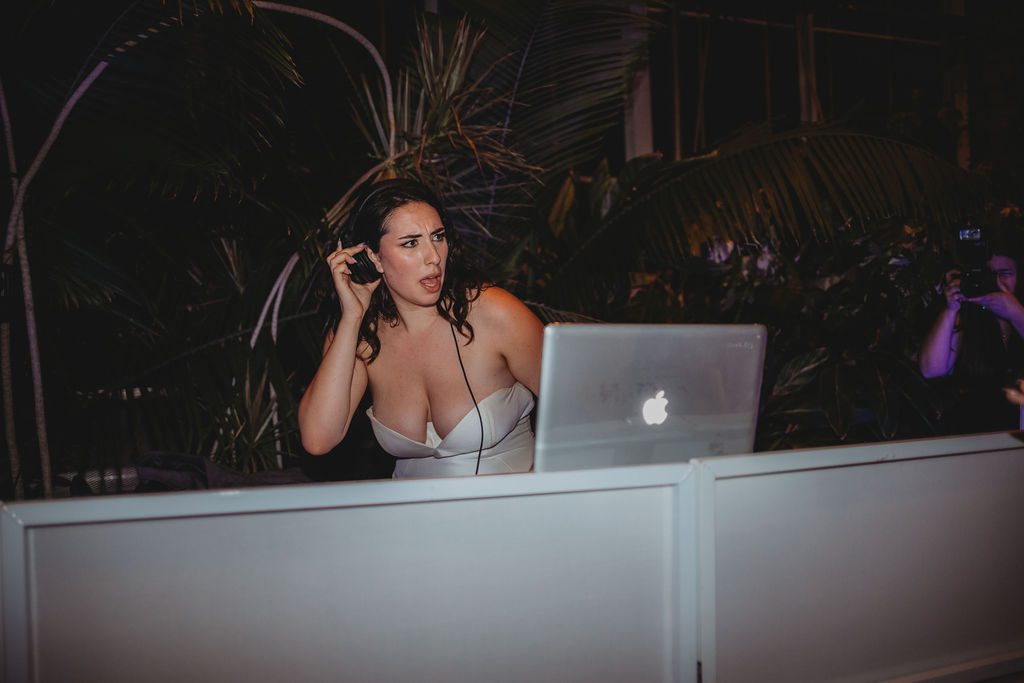 Bride deejaying during her wedding reception at Roger Williams Botanical Garden Park in Providence, Rhode Island.