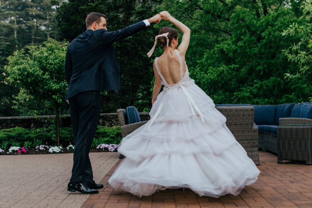 Groom spinning bride outside at The Conner Center in Dover, Massachusetts.