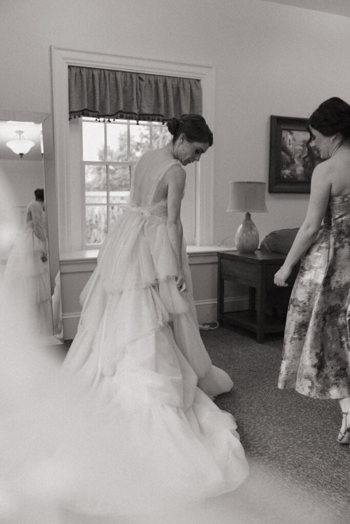Bride putting on her wedding dress in bridal suite at The Conner Center in Dover, Massachusetts.