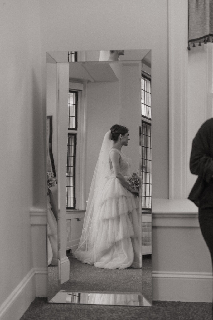 Brides reflection in a mirror in bridal suite at The Conner Center in Dover, Massachusetts.