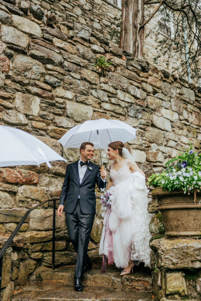 Romantic bride and groom walking down stone staircase looking at each other a\ at The Conner Center in Dover, Massachusetts.