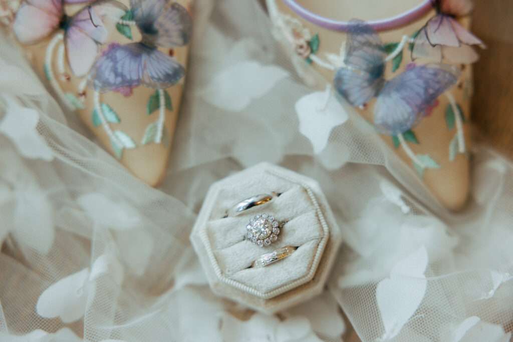 Whimsical flat lay of wedding rings and shoes at The Conner Center in Dover, Massachusetts.