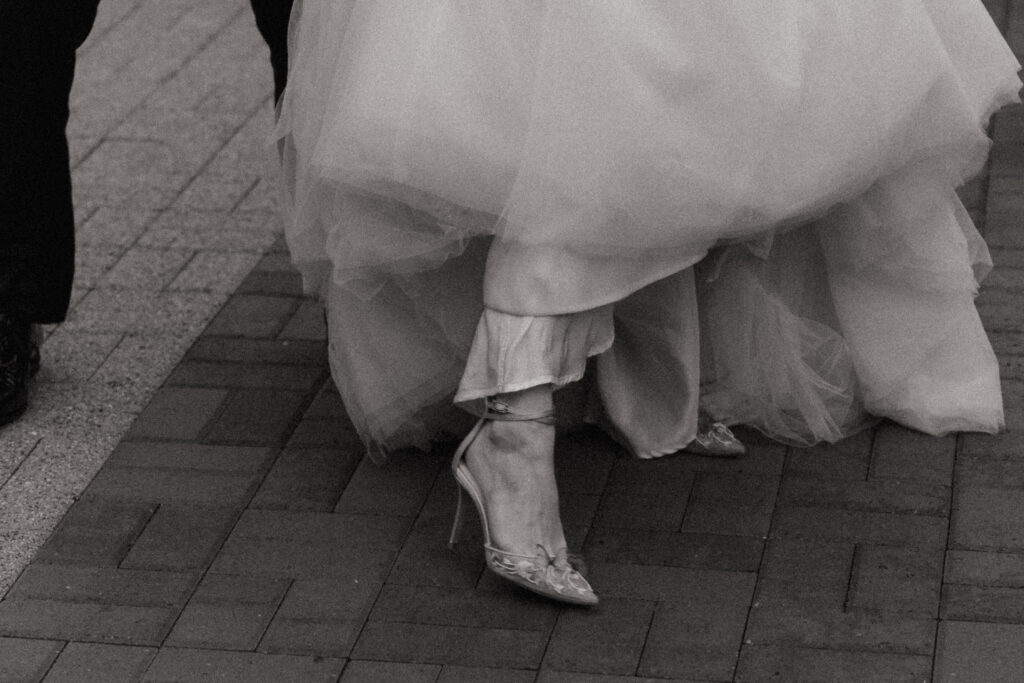 Bride showing her shoes under her wedding dress at The Conner Center in Dover, Massachusetts.