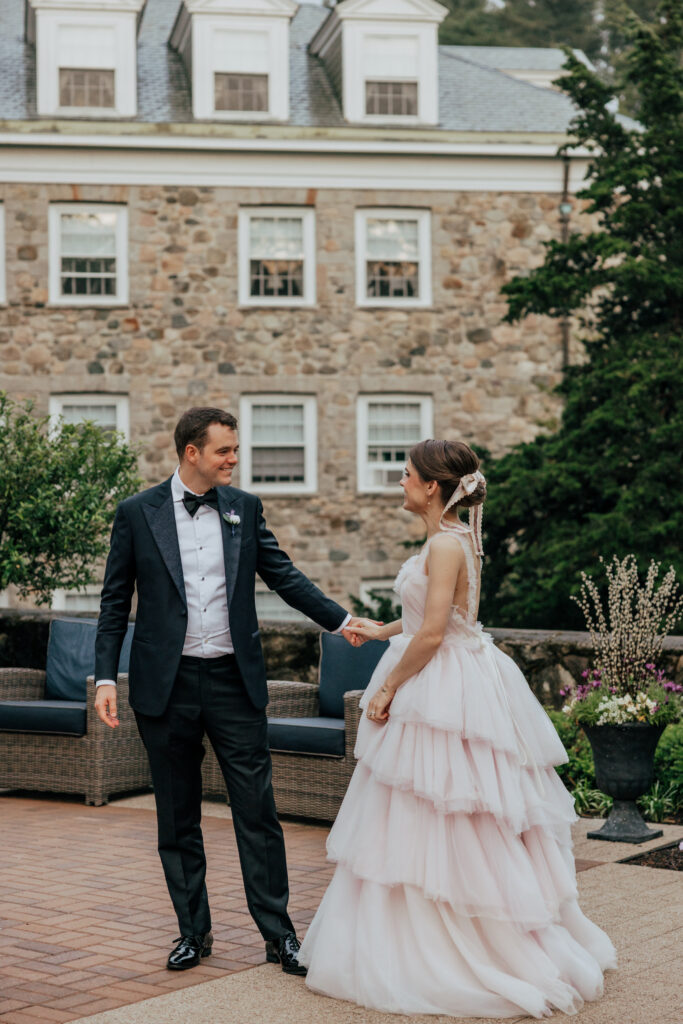 Groom spinning bride in front of stock building The Conner Center in Dover, Massachusetts.